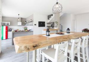 uma grande mesa de madeira numa cozinha com cadeiras brancas em B&B Stella Maggiore em Verbania
