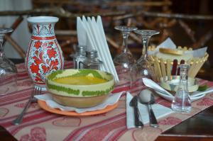 una mesa con un tazón de sopa en una mesa en Popas Azuga, en Azuga