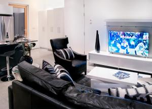 a living room with a couch and chairs and a television at The Cube in Cowichan Bay