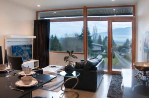 a living room with a couch and a large window at The Cube in Cowichan Bay