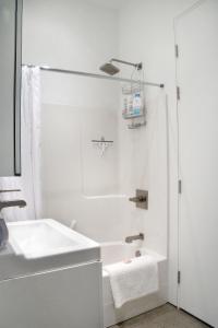 uma casa de banho branca com um lavatório e uma banheira em The Cube em Cowichan Bay