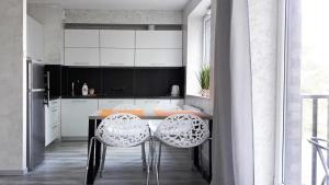 a kitchen with a table and two white chairs at Art Apartments in Wrocław