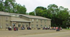 un grupo de motocicletas estacionadas fuera de un edificio en SunRise Inn Hotel, en Mondovi