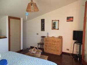 チェファルにあるMazzaforno Graziosa Villetta Relaxのベッドルーム(ベッド1台、テレビ、ドレッサー付)