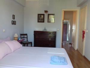 a bedroom with a white bed and a dresser at Blue Sky appartment in Pallini