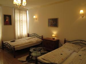 ウィーンにあるSmall Luxury Kapitol Apartmentのベッドルーム1室(ベッド2台、テーブル、ランプ2つ付)
