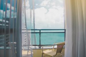 a balcony with two chairs and a view of the ocean at JOH Blue Ocean Flat Hotel in Fortaleza