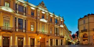 a large yellow building with lights on it at Cristina's Flat in Asti