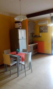 a kitchen with a table and chairs and a refrigerator at Cristina's Flat in Asti +15 photos