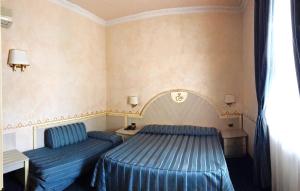 a bedroom with two blue beds and a window at B&B Villa Primavera in Pisa