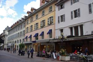 Un groupe de personnes marchant dans une rue avec des bâtiments dans l'établissement Guest VIP Annecy Lake, à Annecy