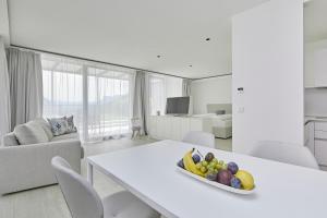 a white living room with a table with a bowl of fruit at The View Luxury Suites in Lagundo