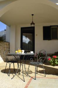 een tafel en 2 stoelen op een patio bij Masseria Asciano in Ostuni