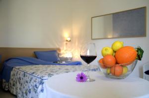 a bowl of fruit and a glass of wine on a table at Masseria Asciano in Ostuni