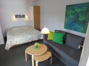 una camera da letto con un letto, un divano e un tavolo di Motel Garni Blåvand a Blåvand