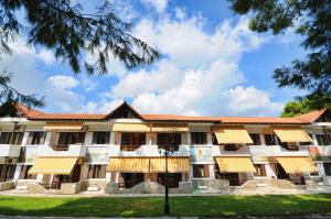 an exterior view of a building with yellow awnings at Haus Platanos Apartments & Bungalows by the Sea in Vourvourou