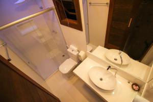 a bathroom with a sink and a shower and a toilet at Pousada João Sol in Praia do Forte +37 photos