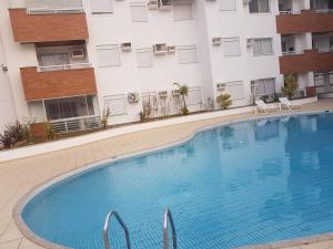 uma grande piscina em frente a um edifício em Apto de 02 qtos no Ingleses - Florianopolis - SC em Florianópolis