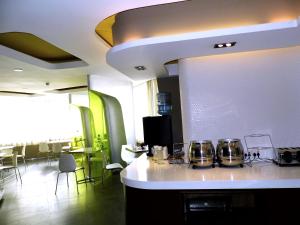 Jinjiang Inn Taiyuan University Street Hotel في تاييوان: مطبخ مع كونتر مع القدور والمقالي