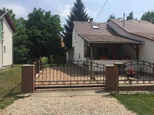 a gate in front of a white house at Arborétum in Harkány