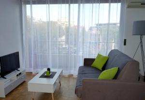 a living room with a couch and a large window at Appartement Perpignan Centre Place Catalogne in Perpignan