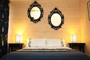 a bedroom with two mirrors on the wall and a bed at Maison Addama in Neyron