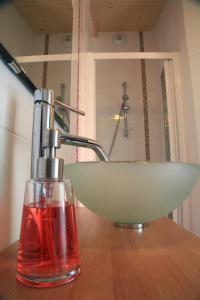 a bathroom sink with a soap dispenser on a table at Maison Addama in Neyron