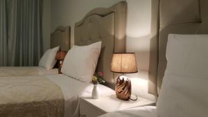 een slaapkamer met 2 bedden en een lamp op een nachtkastje bij Terraza Apart Hotel in Pichanaki