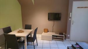 ein Esszimmer mit einem Tisch und einem TV an der Wand in der Unterkunft Le Jim : Rue Musette in Dijon