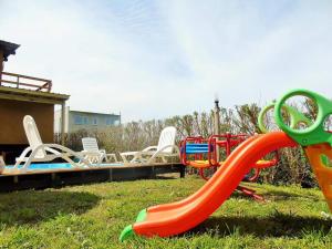 a group of chairs and a slide on a playground at Mini Complejo El Encuentro in Sierra de los Padres