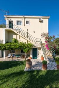 a large white house with stairs and potted plants at Maria's House in Katelios +24 photos