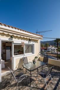 a patio with a table and chairs on a balcony at Maria's House in Katelios