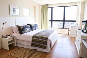 a bedroom with a bed and a large window at Vitória Hotel Convention Paulínia in Paulínia