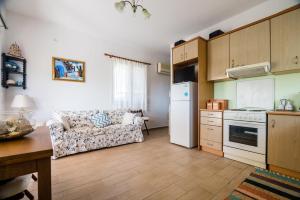 a living room with a couch and a kitchen at Maria's House in Katelios