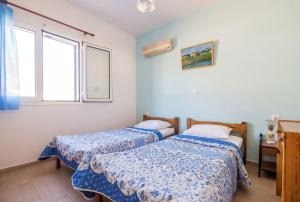two beds in a room with two windows at Maria's House in Katelios