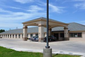 a large building with a pole in front of it at Irish Inn and Suites in Muleshoe