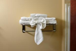 a towel rack with towels and a bow on it at Irish Inn and Suites in Muleshoe