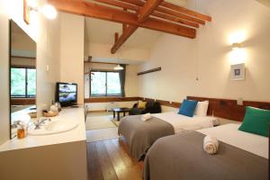 a hotel room with two beds and a sink at Momiji in Otari