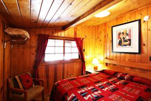 a bedroom with a red bed and a window at Three Bears Lodge in Red River
