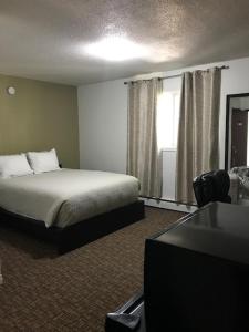 a hotel room with a bed and a television at Grizzly Motel in Swan Hills