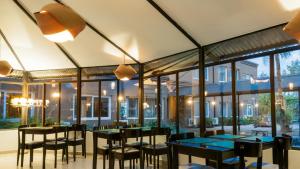 un restaurante con mesas, sillas y ventanas grandes en Pro Hotel en Pilar
