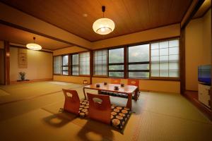 a room with a table and chairs and windows at Namegawaonsen Fukushimaya in Yonezawa
