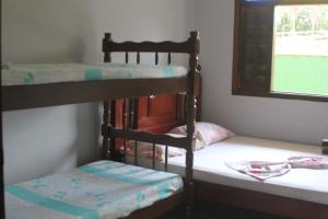 two bunk beds in a room with a window at Oásis Pousada in Bertioga +25 photos
