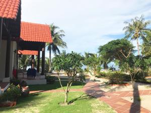 a house with a palm tree in the yard at Peppercorn Beach Resort in Phú Quốc