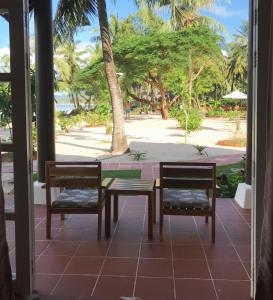 a patio with two chairs and a table with a view of the beach at Peppercorn Beach Resort in Phú Quốc