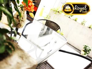 uma cadeira sentada numa mesa ao lado de uma planta em Hotel Royal Suite em Manizales