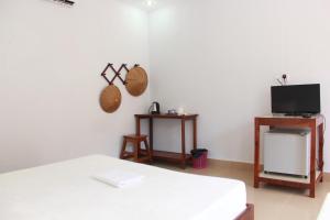 a living room with a bed and a tv at Manita Anna Guesthouse Jullyanna before in Sihanoukville