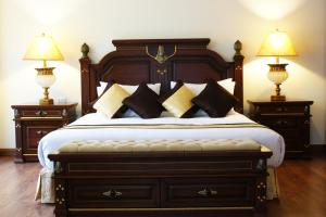 芭堤雅市中心LK大都会酒店的一间卧室配有一张大床、枕头和两盏灯。