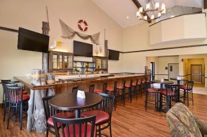 eine Bar in einem Restaurant mit Tischen und Stühlen in der Unterkunft Best Western Plus Emory at Lake Fork Inn & Suites in Emory