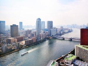 a river with a boat in the middle of a city at Ginza Creston in Tokyo